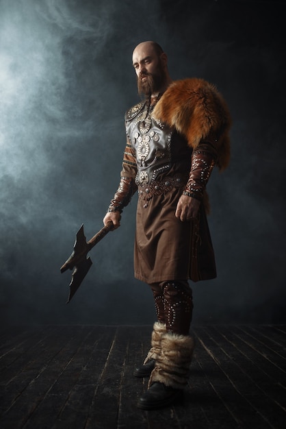 Handsome viking with axe dressed in traditional clothes