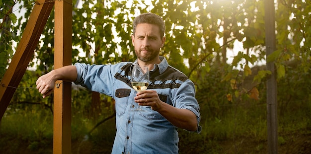 Handsome viticulturist man farmer drink wine at grape farm winegrower