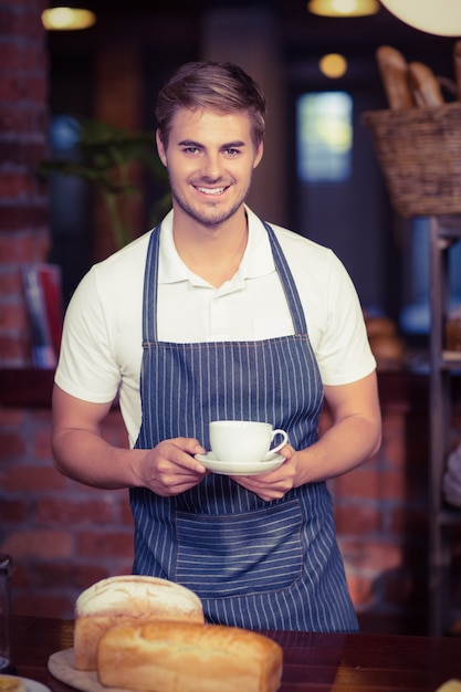 Foto cameriere bello che tiene una tazza di caffè