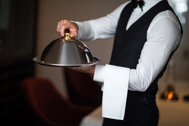 Photo handsome waiter holding tray