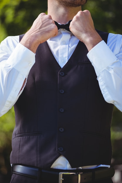 Handsome waiter reattaching his bow tie