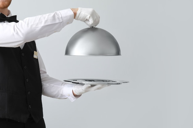 Handsome waiter with tray and cloche