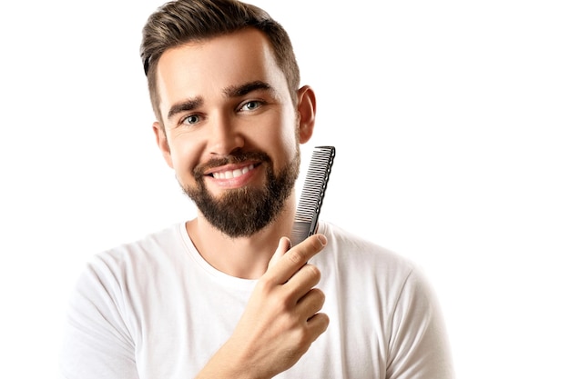 Handsome well groomed man combing his beard on white background