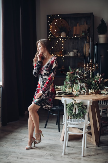 Handsome woman waits guests in the kitchen