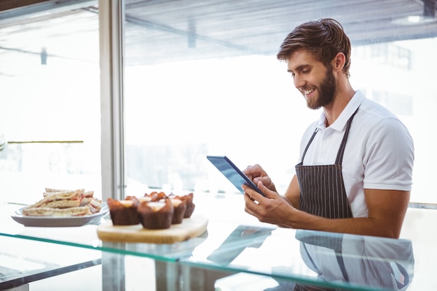  Handsome worker posing on the counter with a tablet 