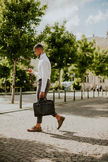 Handsome young African American businessman using a mobile phone on a street