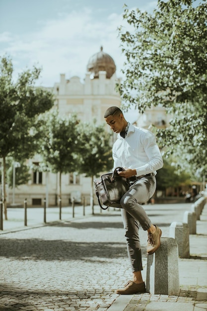 Handsome young African American businessman waitng for a taxi waitng a taxi on a street