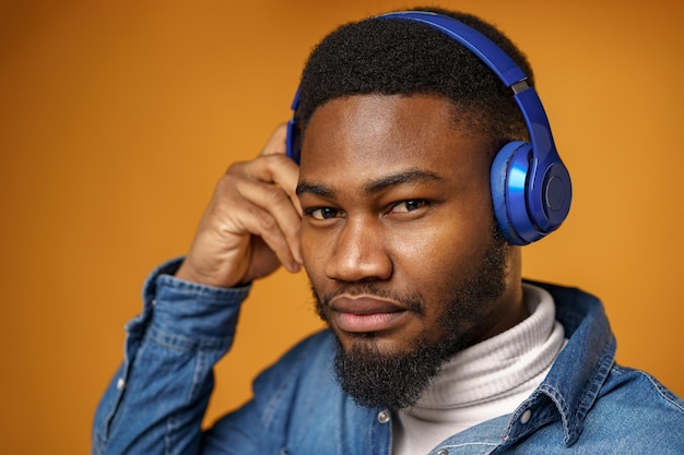 Handsome young african american man listening to music with blue headphones