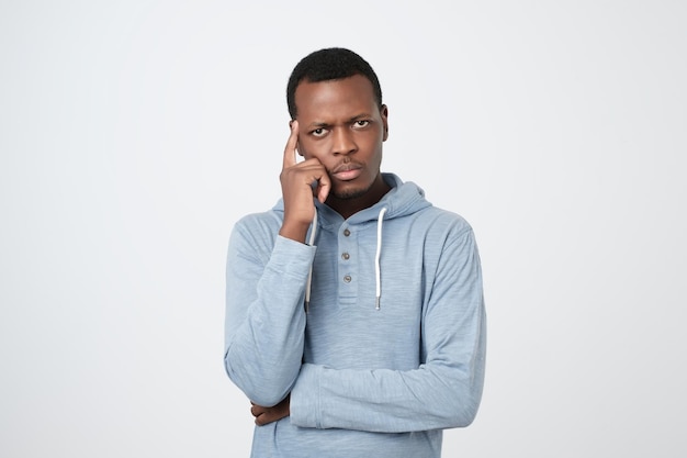 Photo handsome young african american man looking up with thoughtful and skeptical expression