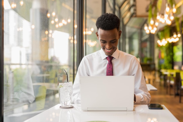 Handsome young African businessman in coffee shop restaurant