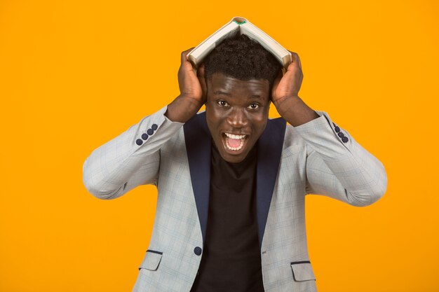 Handsome young african male in a jacket reading a book