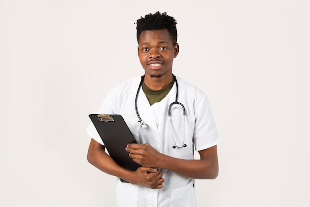 handsome young african male on a white background in a medical gown with a folder in his hands