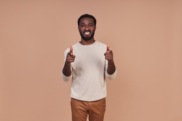 Handsome young African man in casual clothing looking at camera and smiling