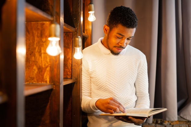 handsome young african man reading a book