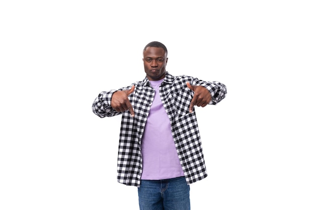 Handsome young american man in a plaid shirt shows his hand at the promotional offer on the wall