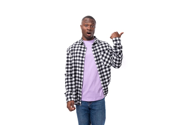 Handsome young american man in a plaid shirt shows his hand at the promotional offer on the wall