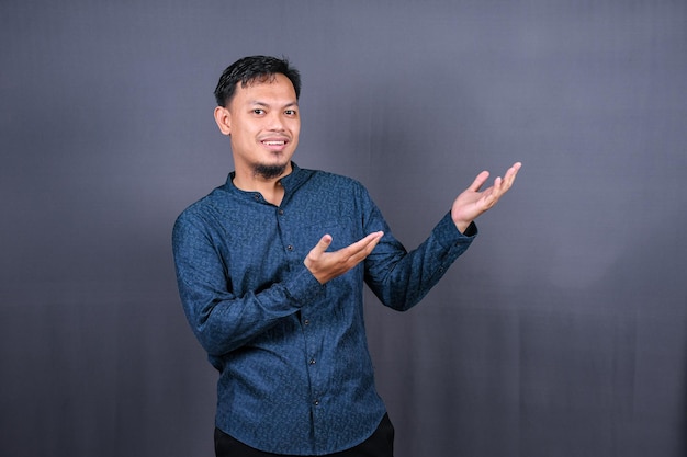 Handsome young asian man on grey background. Moslem, Indonesia