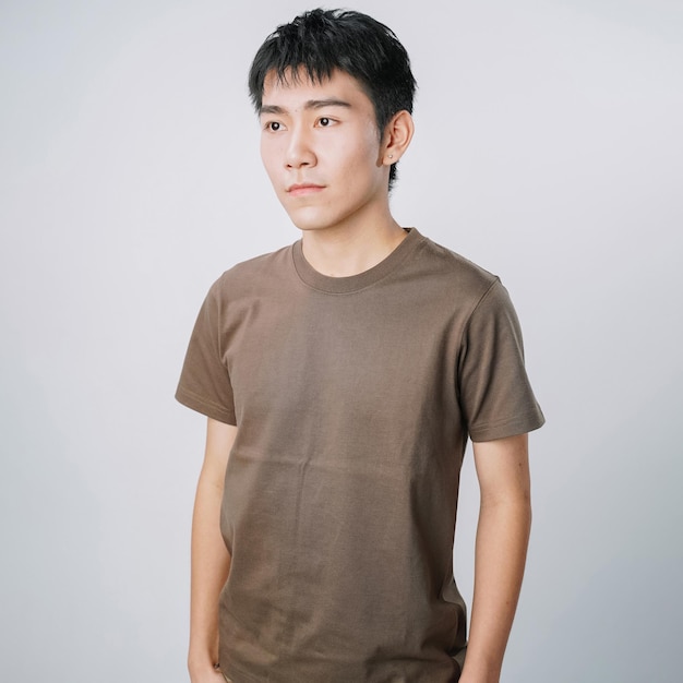 Photo handsome young asian man tshirt standing neutral  isolated gray wall