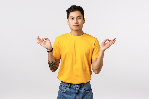 Handsome young asian man in yellow t-shirt in peace