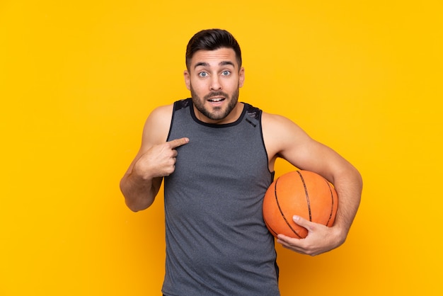 Handsome young basketball player man over isolated white wall with surprise facial expression