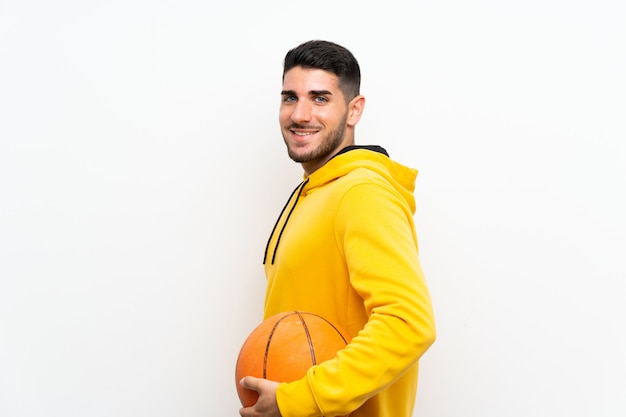 Handsome young basketball player man over isolated white wall 