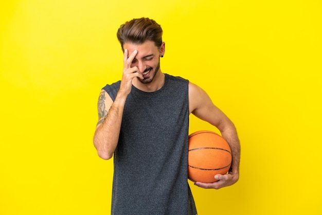 Handsome young basketball player man isolated on yellow background laughing