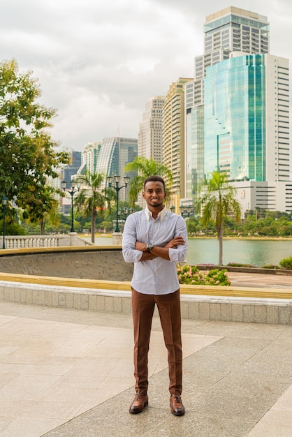 Handsome young black businessman at park outdoors during summer