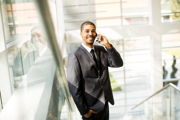 Handsome young black man with mobile phone in the office