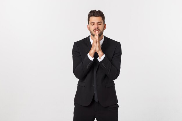 Handsome young business man standing praying