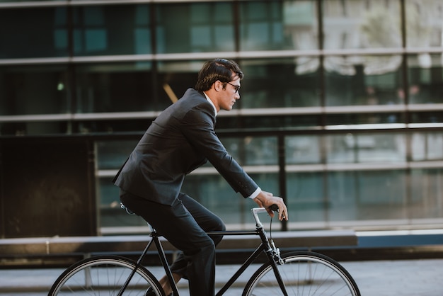 Photo handsome young business man with his modern bicycle.