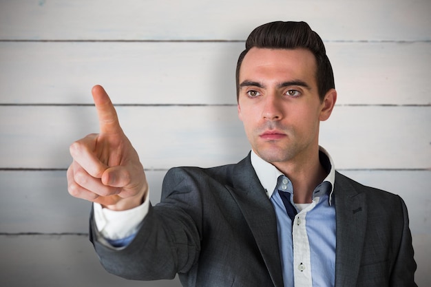 Handsome young businessman pointing against painted blue wooden planks