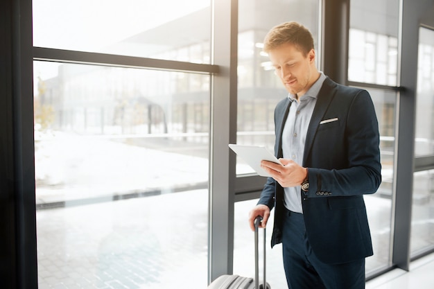 Handsome young businessman stand in airport hall