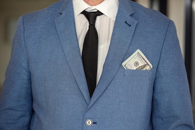 Photo handsome young businessman in a stylish jacket from a suit with a large sum of dollars