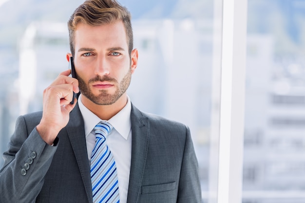 Handsome young businessman using mobile phone