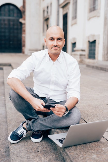 Handsome young businessman in a white shirt working with laptop 