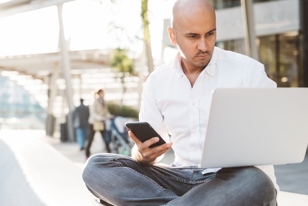 Handsome young businessman in a white shirt working with laptop 