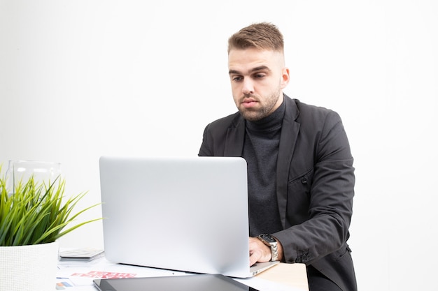 Handsome young businessman working on a laptop