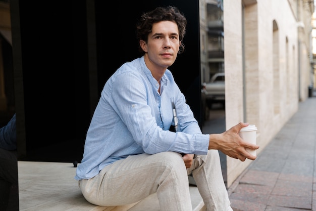 Handsome young casual man drinking coffee