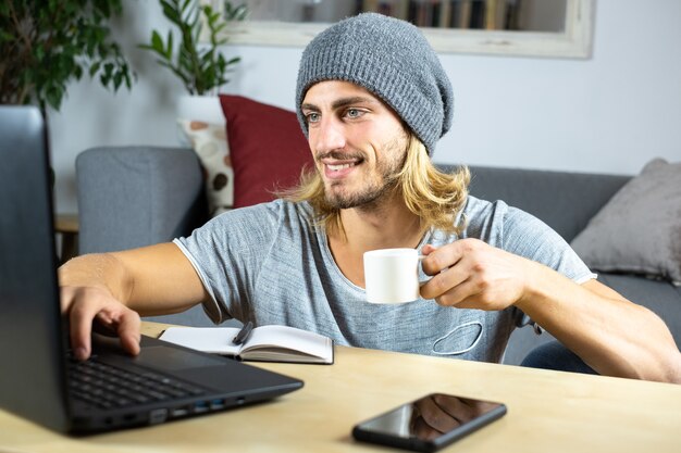 Photo handsome young caucasian man working at home