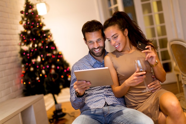 Handsome young couple shopping with tablet at New Years eve