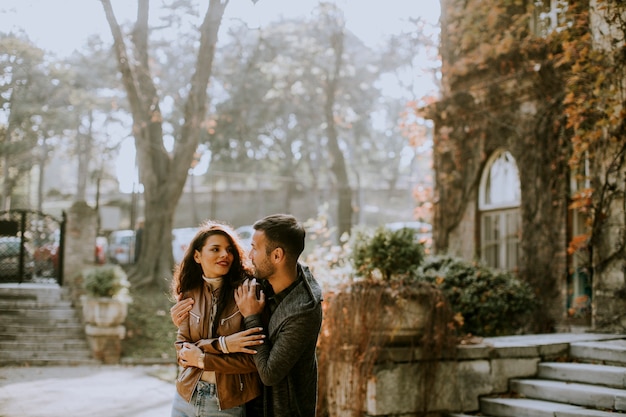 Handsome young couple standing by the stairs of the old house