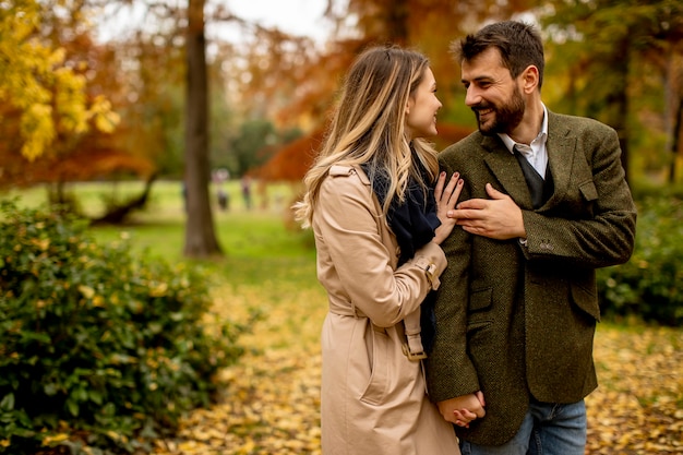 Bella giovane coppia che cammina nel parco autunnale