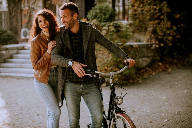 Handsome young couple walking with bicycle in autumn park