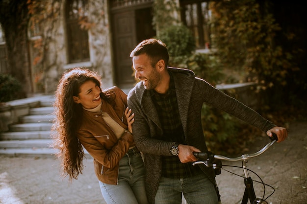 Handsome young couple walking with bicycle in autumn park