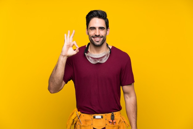 Handsome young craftsman showing ok sign with fingers