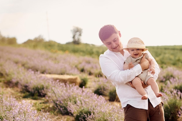 Handsome young dad in playing with son in lavender field