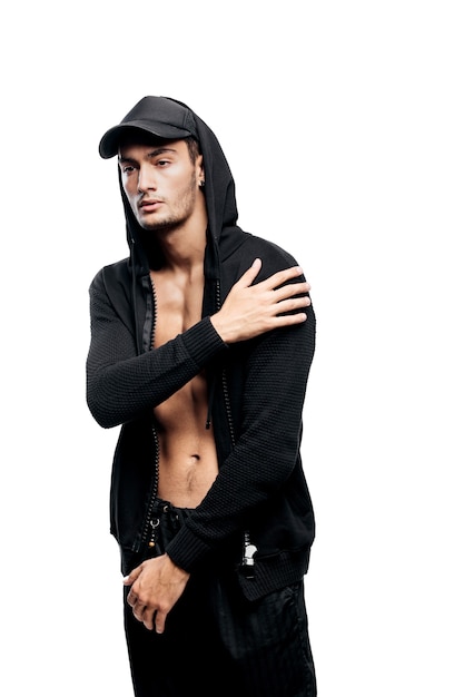 Photo handsome young dancer dressed in black pants, a sweatshirt and a hood on the cap