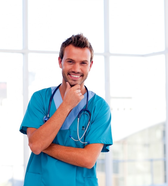 Handsome young doctor isolated smiling at the camera