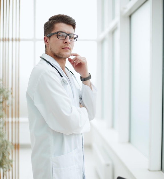 Handsome young doctor portrait in medical office