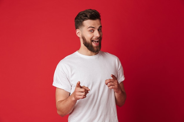 Handsome young emotional man pointing. Looking camera.